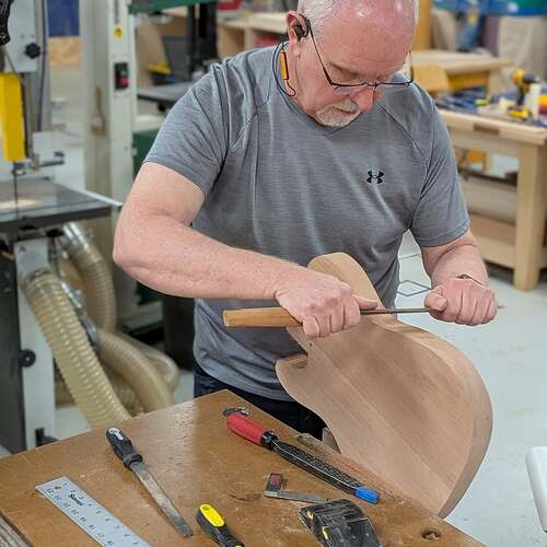 Student shaping a body with hand tools