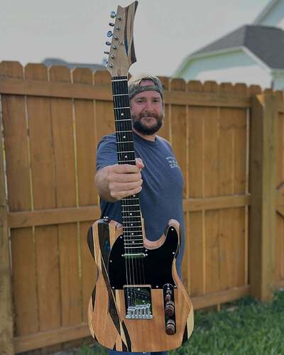 Scott holding his finished TE-style DIY guitar build with a striking striped body
