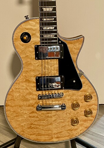 Close-up of the quilted maple veneer top, chrome humbuckers and gold top hat knobs