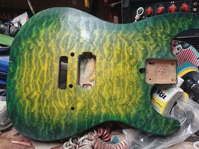 Tom's guitar body, a quilted maple veneer top dyed yellow under green, photographed on the bench before clear coat