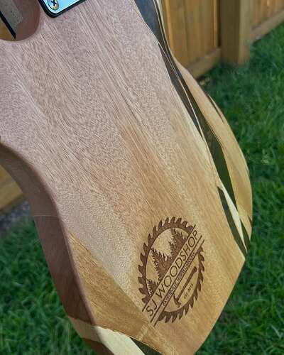 The SJ Woodshop logo laser-engraved into the back of Scott's guitar